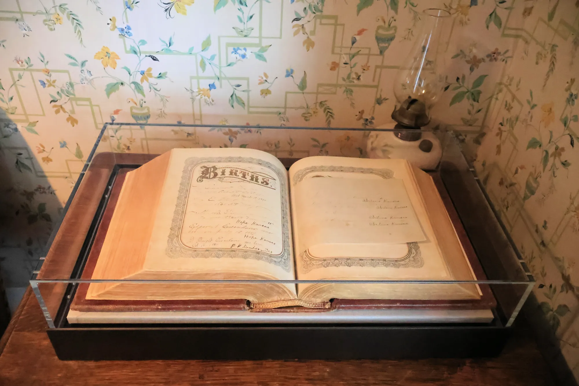 Open family Bible displayed under glass in a museum room