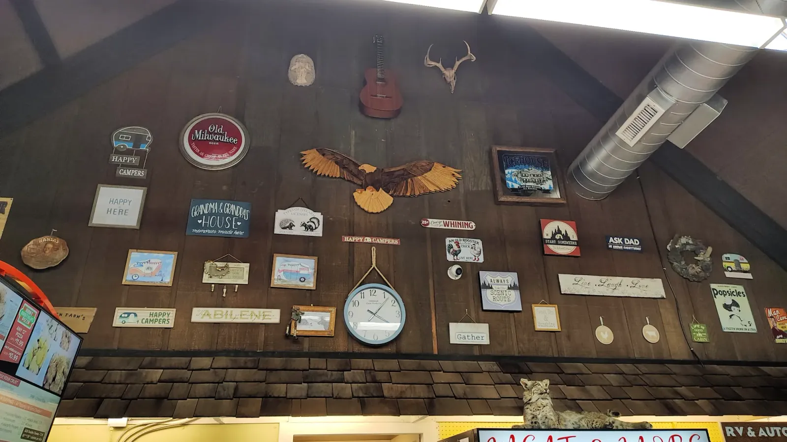Rustic store counter with mounted fish plaques and guitars on a wood wall